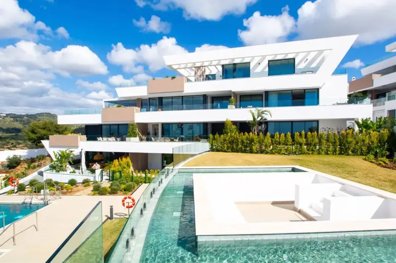 Edificio blanco de Artola Alta con terrazas y piscina en Marbella