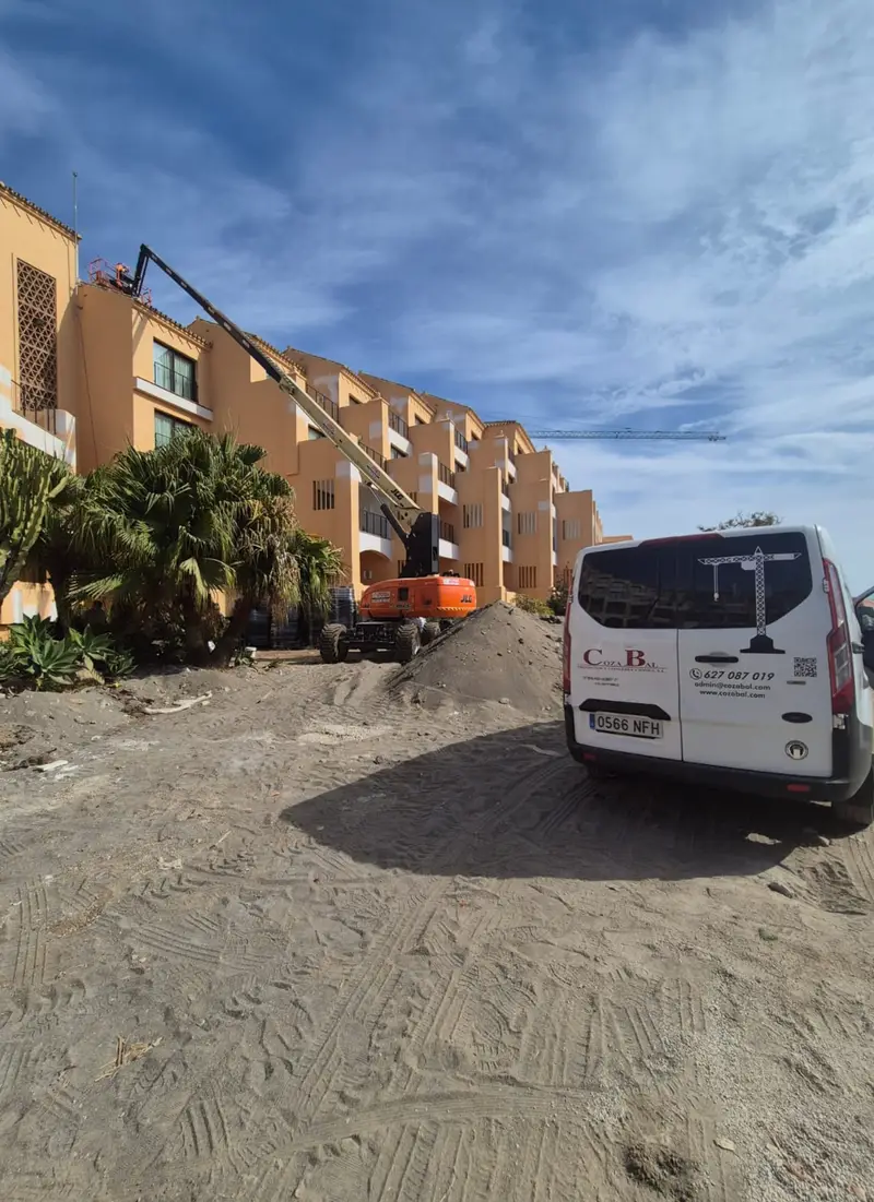 Edificio en obra con plataforma elevadora y furgoneta de Cozabal